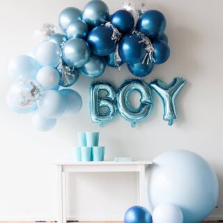 Lichtblauwe follieballonnen met de tekst 'boy' boven een tafel met lichtblauwe bekers en een blauwe ballonnenboog