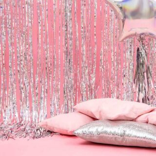 Roze wand met holografisch deurgordijn rose kussens en een folie ballon ster