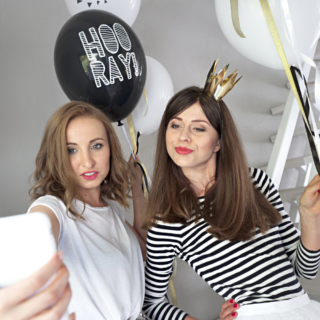 twee vrouwen maken een selfie met een gouden kroontje op