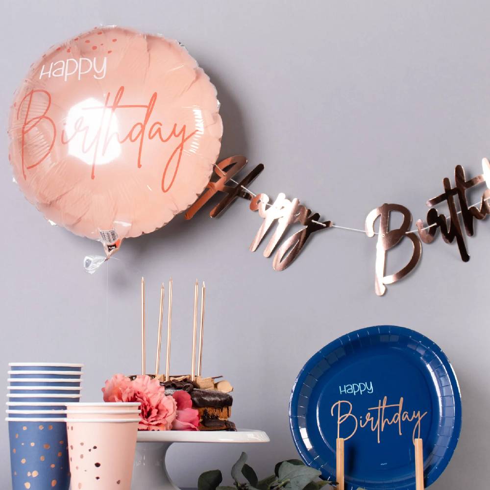 Tafel met blauwe en roze versiering en taart met kaarsen
