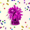 Ballongewicht van 130 gram in het roze op een lichtgele achtergrond met confetti