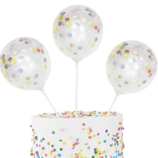 Drie stokjes met ballon erop gevuld met confetti in taart