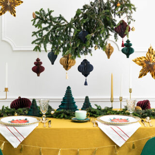 gedekte tafel met kerstgroen en papieren kersthangers