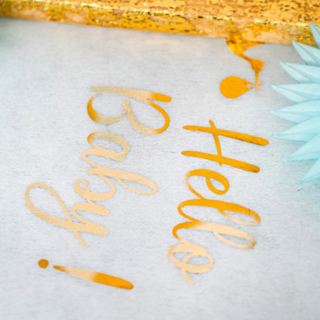 Witte stoffen tafelloper met gouden letters hello baby erop