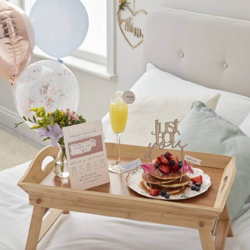 Ontbijt op bed met pannekoeken en rosé gouden en roze versiering