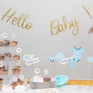 gouden slinger hello baby boven een witte tafel met blauwe versiering en een cupcake toren