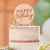 Taart met wit glazuur en een houten topper met de tekst 'Happy Birthday'