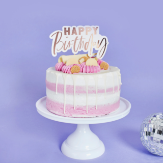 Wit plateau met een roze en witte taart en rose gouden taart topper met de tekst happy birthday