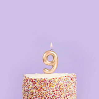 gouden cijfer 9 in een taart voor een paarse muur