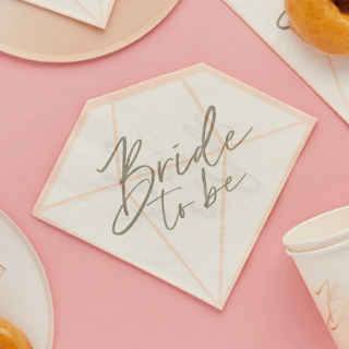 servetten in de vorm van een diamand in het wit met perzikkleur en gouden tekst bride to be op een roze achtergrond