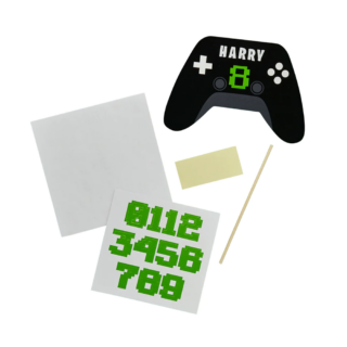 personaliseerbare taart topper in de vorm van een zwarte controller met stickervellen in het groen en wit