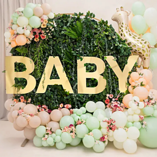 bosje versierd met gouden letters baby en pastelgroene en perzikkleurige ballonnen