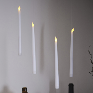 Zwevende, witte kaarsen met LED verlichting hangen boven bruine vaasjes en takken