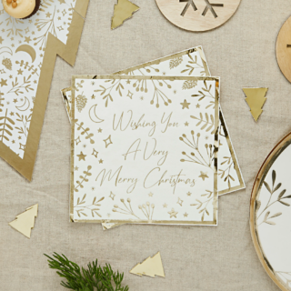 Servet in het wit en goud met de tekst wishing you a very merry christmas ligt op een jute tafelkleed met gouden confetti in de vorm van kerstbomen