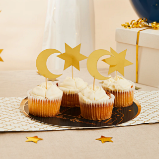 Cupcakes op een zwart bord versierd met gouden prikkers met sterren en maantjes erop