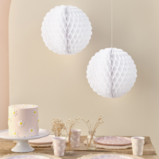 Witte honeycombs met geribbelde rand hangen boven roze en witte madeliefjes versiering