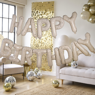 Happy birthday ballonnen in het nude en goud hangen voor een gouden backdrop