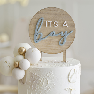 Houten taart topper met de tekst its a boy in het wit en blauw staat in een witte taart