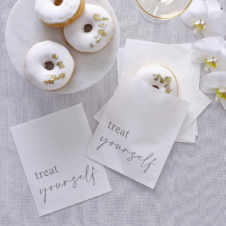 Witte zakjes met de tekst treat yourself zijn gevuld met donuts