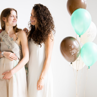 Drie vrouwen poseren tijdens een babyshower met een set ballonnen met mint, grijs en creme ballonnen