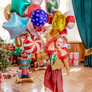meisje met gouden pailletten kraag houdt een bos ballonnen vast