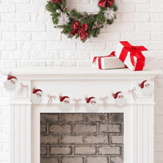 slinger met kerstmannen en roze strikjes hangt aan een witte open haard