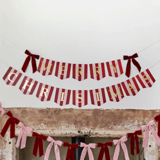 rood en roze gestreepte slinger met gouden tekst merry christmas en rode velvet strikjes