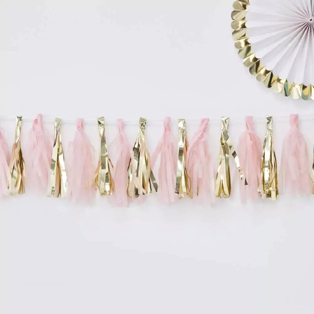 Draad met daaraan roze en gouden tassels en daarboven een wit met gouden waaier