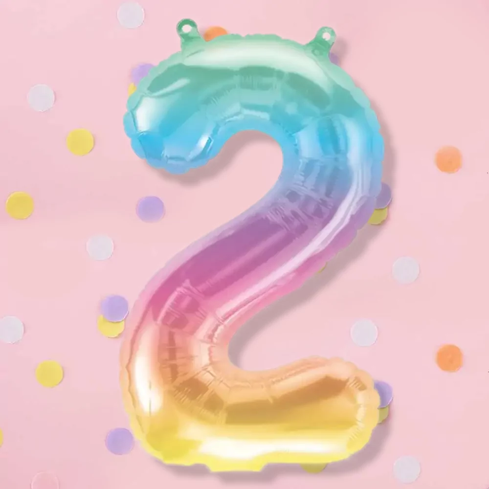 Pastel cijferballon met regenboogkleur op een lichtroze achtergrond met paarse, witte, gele en oranje confetti
