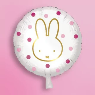 Ronde folieballon met roze stippen en nijntje erop op een roze achtergrond