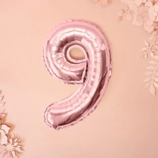 Rosé gouden folieballon cijfer 9 op een lichtroze achtergrond met roze bloemen