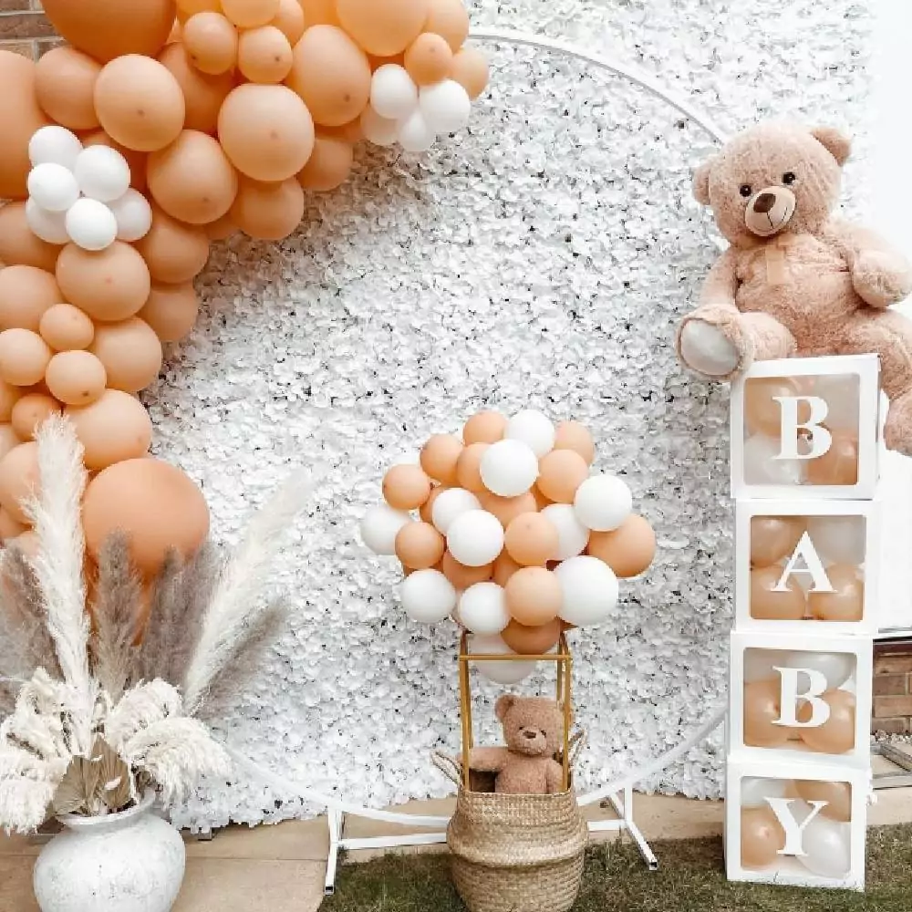 Versierde wand met ballonnenboog met wit en nude kleuren en knuffelberen