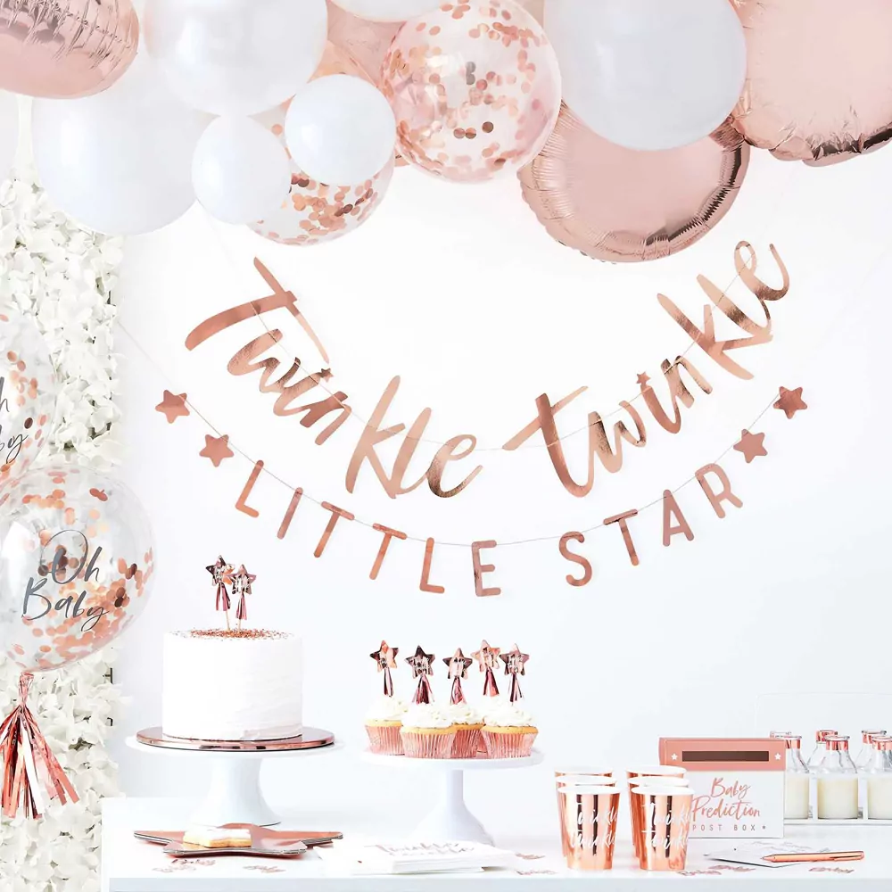 tafel met taart cupcakes en rose gouden babyshower versiering