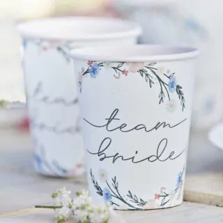 twee witte bekertjes met team bride en bloemenkransen erop
