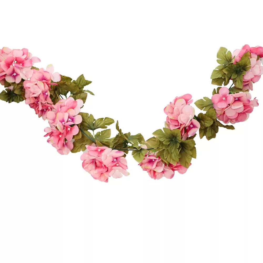 kunstbloemen in roze kleur met groene bladeren er tussen