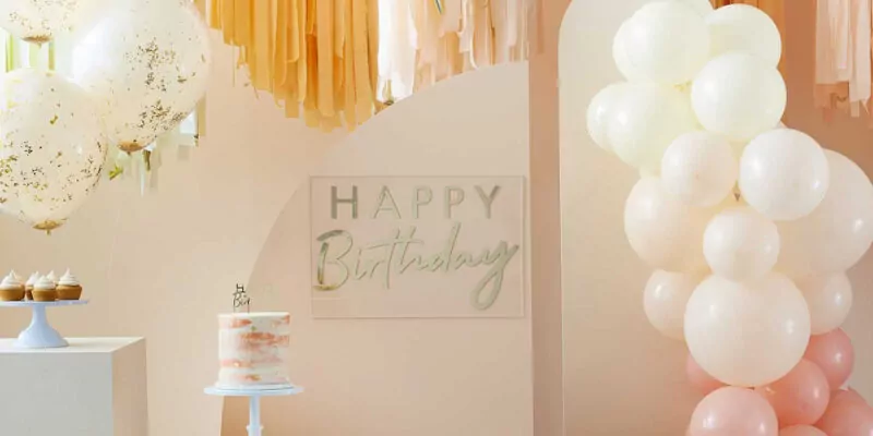 perzikkleurige ruimte met bogen met ballonnen en crepe papier versiering