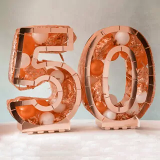 rosé gouden ballonstandaard in de vorm van een 5 en een 0 gevuld met ballonnen en decoratie