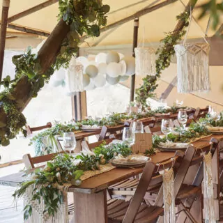 Tent met gedekte tagels en versiering voor bruiloft