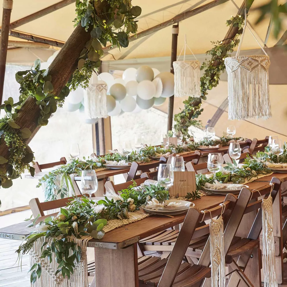 Tent met gedekte tagels en versiering voor bruiloft