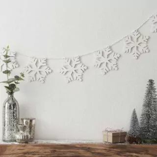 koord met houten sneeuwvlokken met vaasjes en kerstboompjes