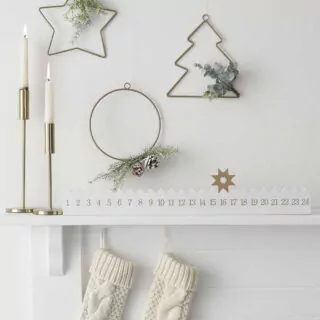 Schouw met kalender kaarsen en drie metalen hangers in diverse vormen