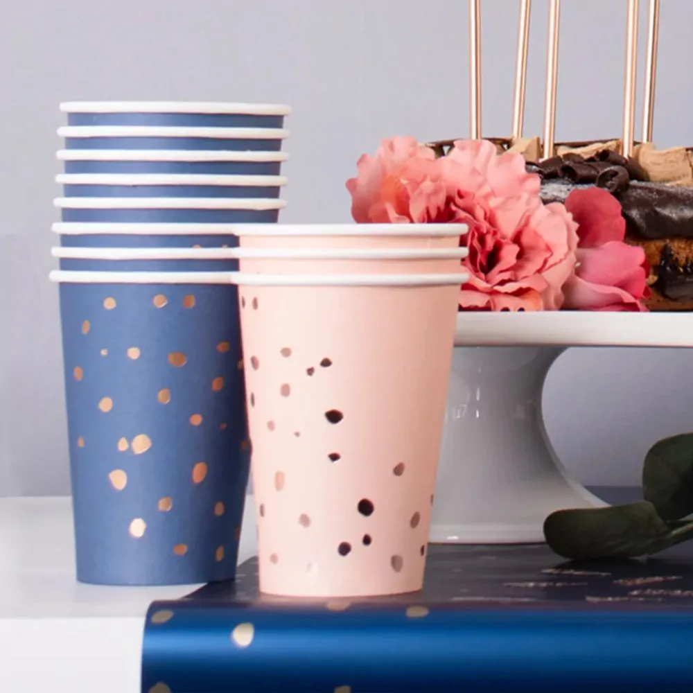 Gedekte tafel met donkerblauwe en roze bekers en bloemen