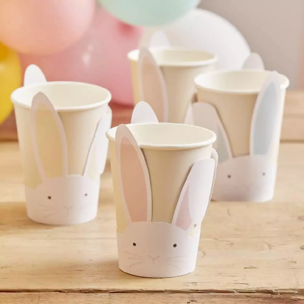Papieren bekers met konijntjes met gekleurde oren op tafel