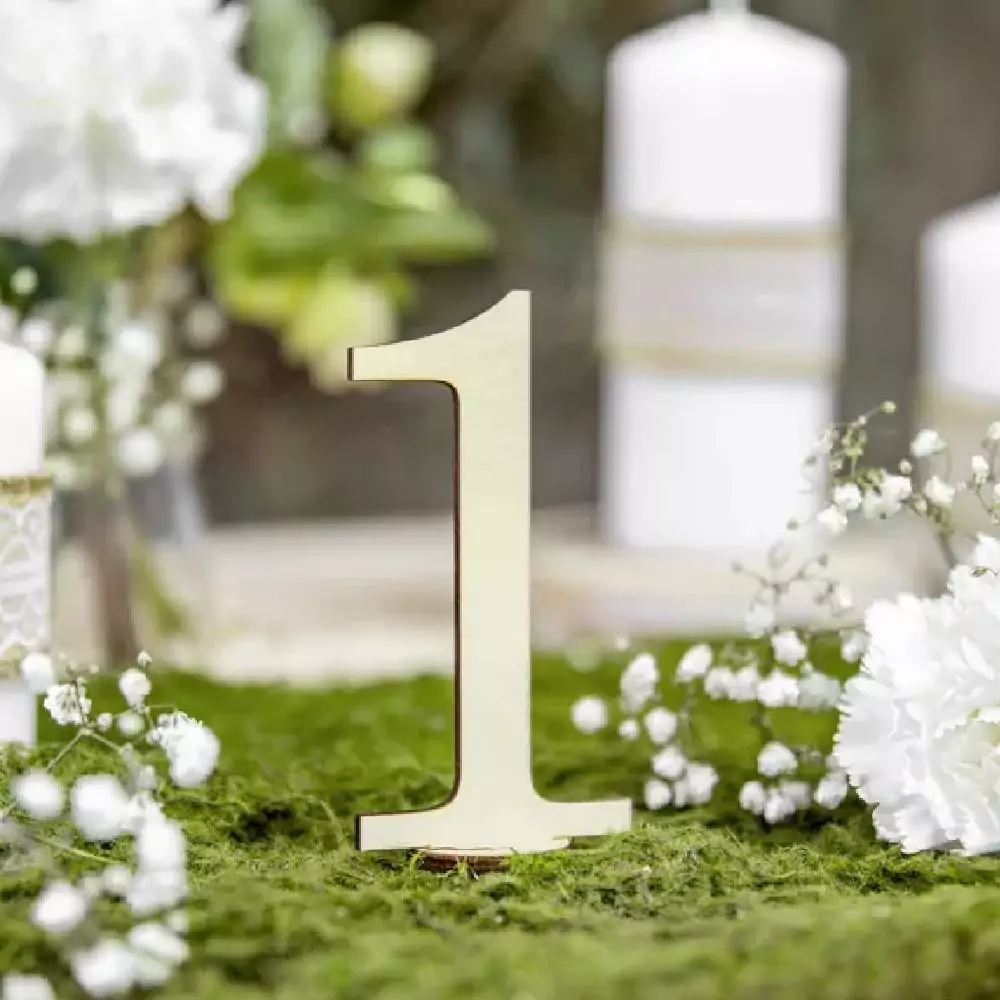 Groen mos met witte bloemen en een houten tafelnummer 1