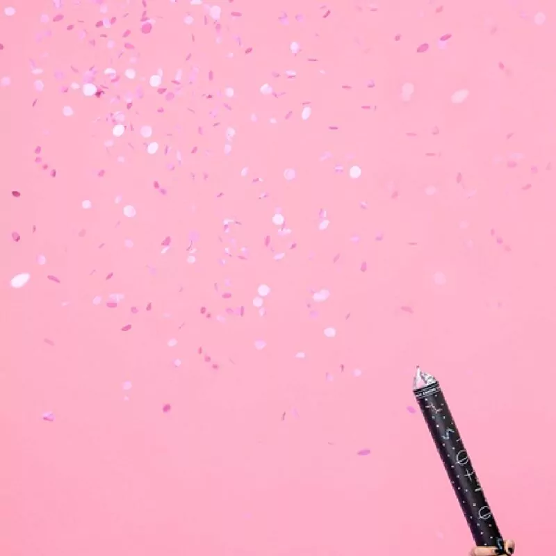 Zwart confettikanon van 60 centimeter met roze confetti
