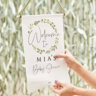 Wit uithangbord hangt voor groen blad met de tekst 'Welcome to Mia's babyshower'