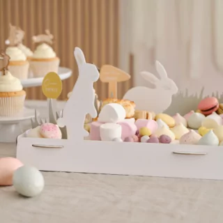 Gedekte tafel met gestipte paaseieren en een witte hapjesplank