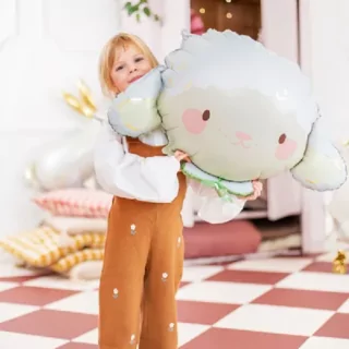 Meisje in bruine overall houd een folieballon vast in de vorm van een schaapje