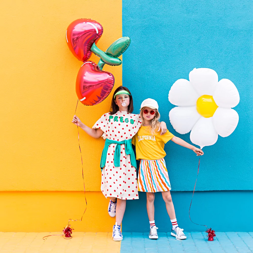 meisjes met ballonnen in de vorm van kersen en een madeliefje