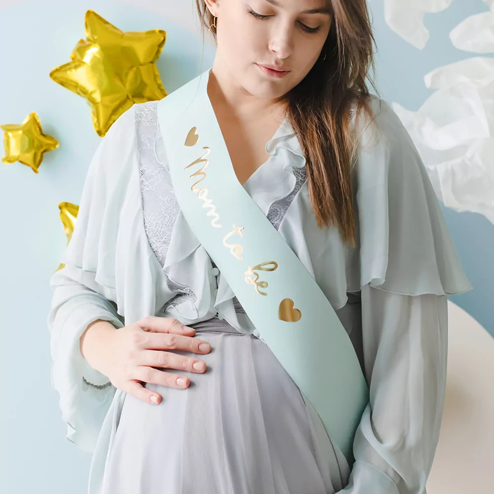 zwangere vrouw met een sjerp om met de tekst mom to be